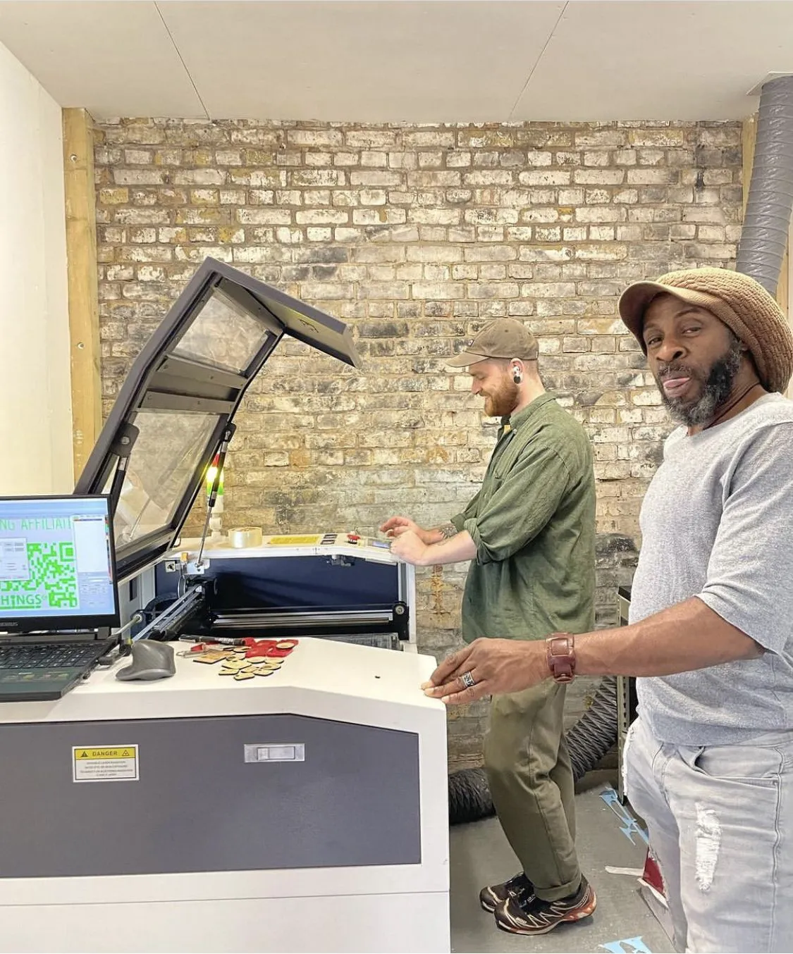 Two members at the laser cutter in the makerspace