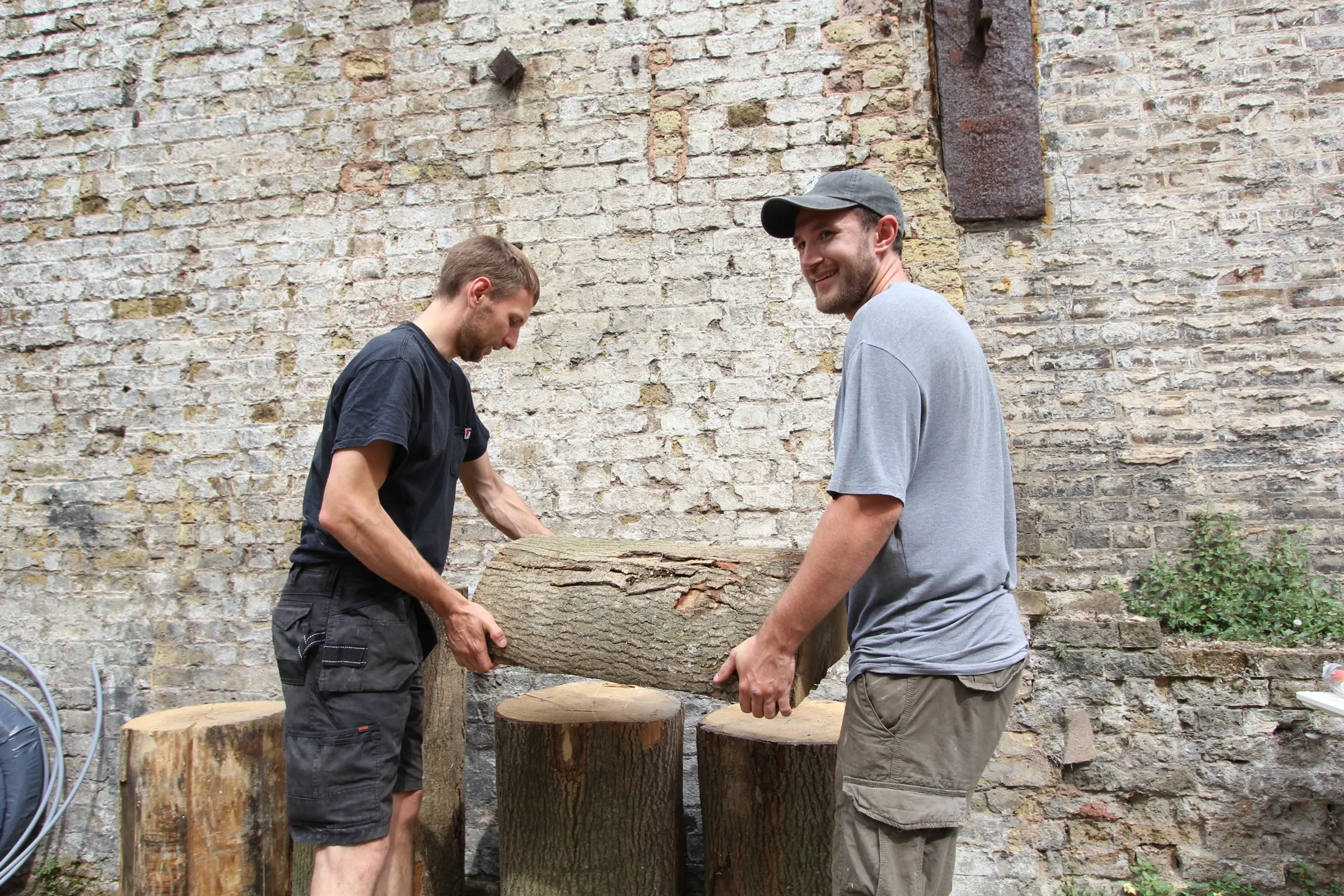 Jack and Mathew moving a log in the yard at Hone Limehouse