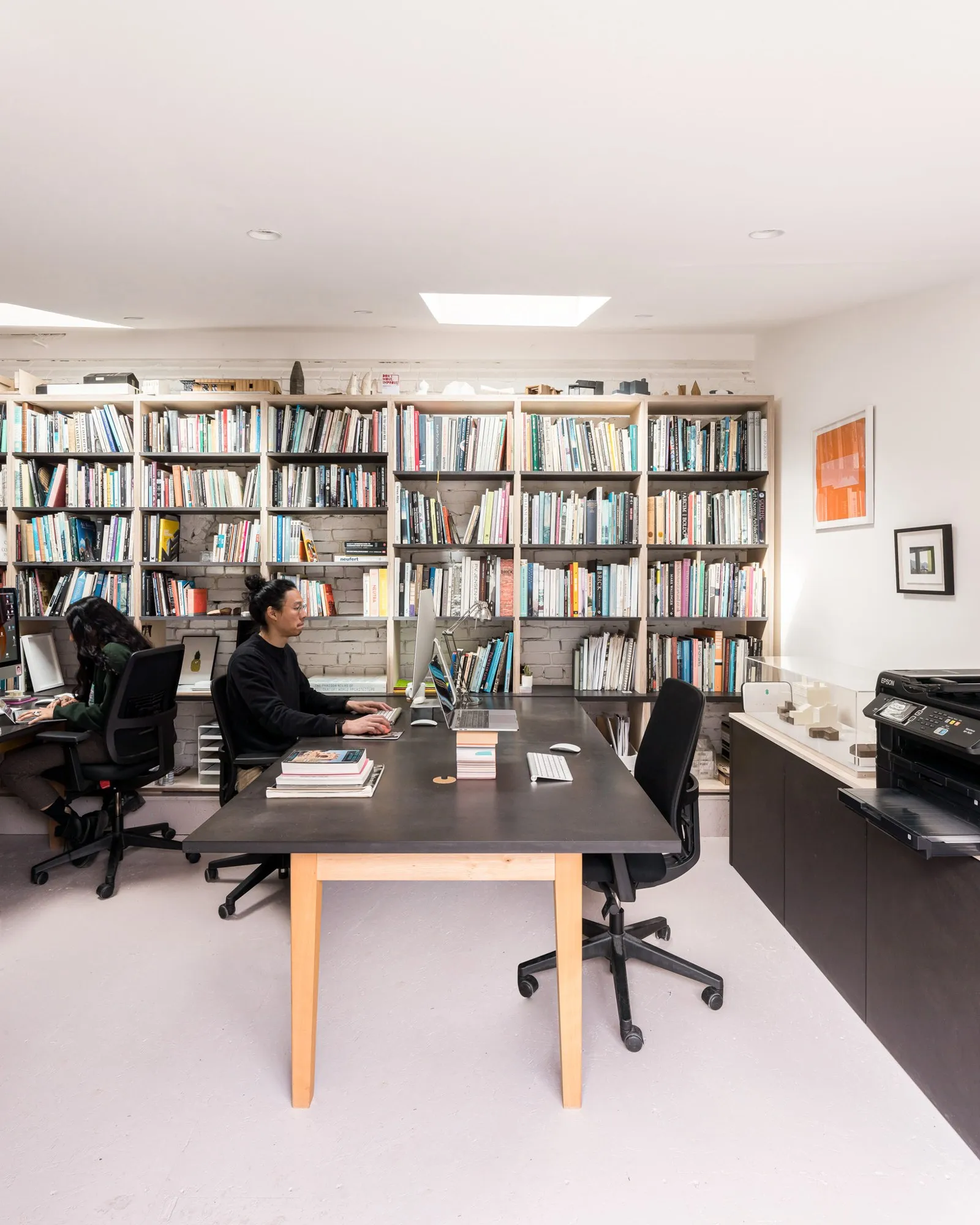 A design studio with a library wall and a long table