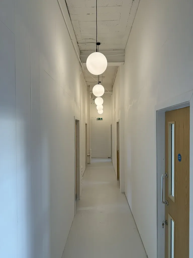 The corridor to the studio workshops at Hone Tottenham, under its globe lights