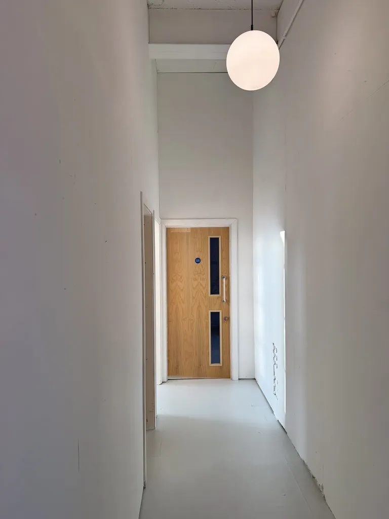 The end of the corridor at Hone Tottenham, under a globe light